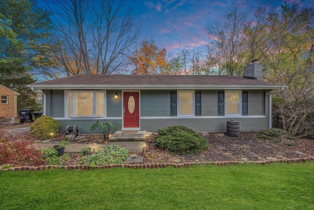 single story home featuring a lawn