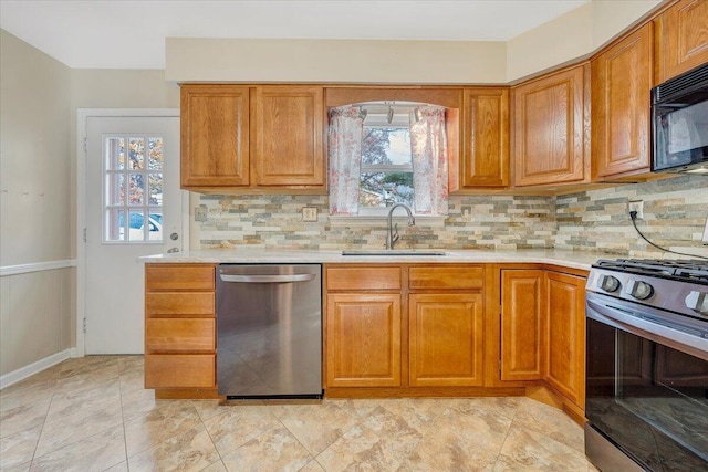 kitchen featuring light tile patterned floors, stainless steel appliances, decorative backsplash, and sink