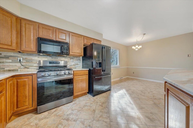 kitchen featuring a notable chandelier, backsplash, hanging light fixtures, and black appliances