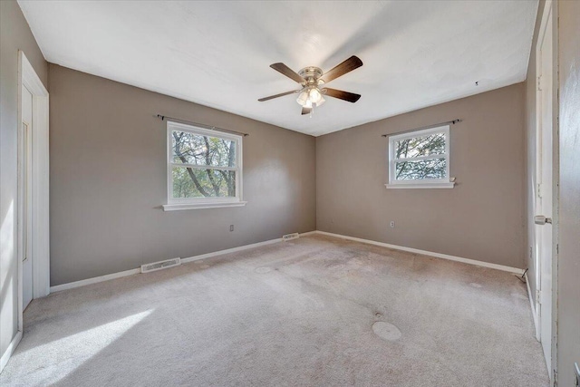 carpeted spare room with ceiling fan and a wealth of natural light