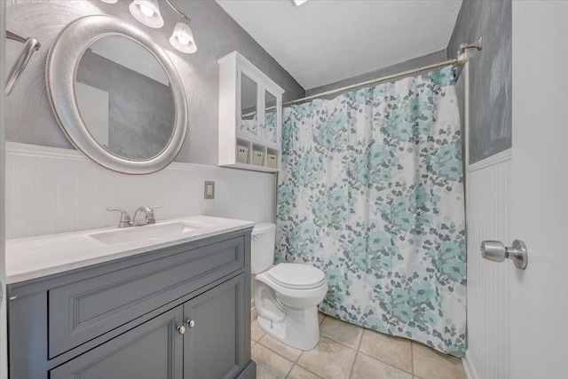 bathroom featuring toilet, wood walls, a shower with shower curtain, tile patterned flooring, and vanity