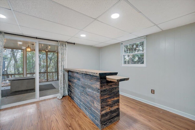 bar featuring a drop ceiling and hardwood / wood-style flooring