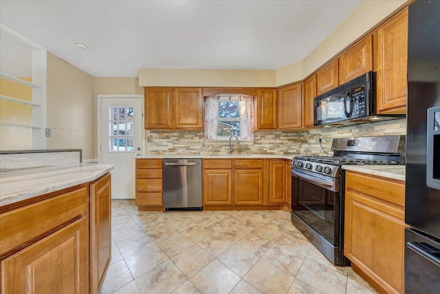 kitchen with sink, a wealth of natural light, decorative backsplash, and black appliances