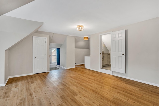 additional living space featuring lofted ceiling and light hardwood / wood-style floors