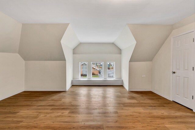 additional living space with lofted ceiling and light hardwood / wood-style flooring