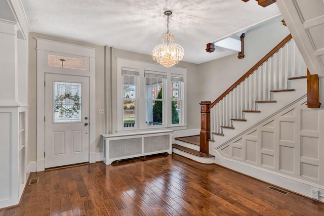 foyer entrance featuring an inviting chandelier, radiator heating unit, and dark hardwood / wood-style flooring