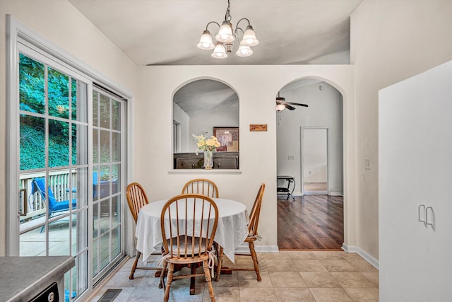 tiled dining room featuring ceiling fan with notable chandelier