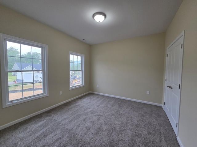 carpeted spare room with baseboards
