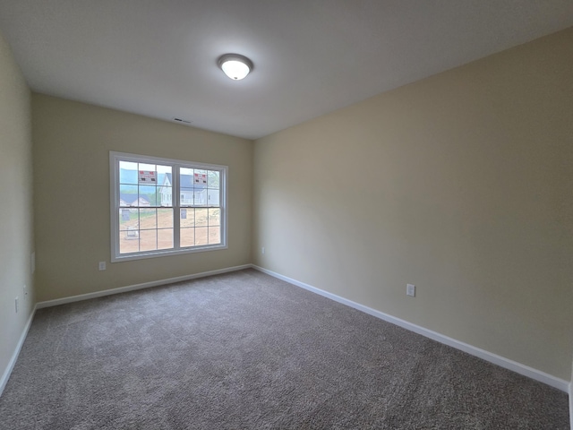 spare room with visible vents, carpet floors, and baseboards