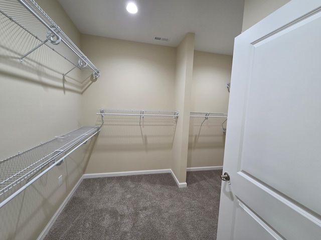walk in closet with visible vents and dark colored carpet