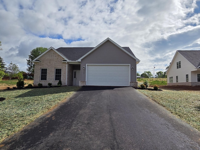 ranch-style home with brick siding, aphalt driveway, roof with shingles, a front yard, and an attached garage