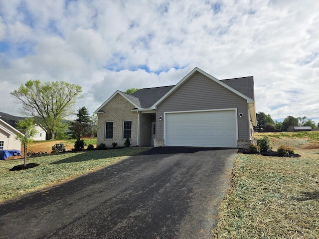 ranch-style home featuring brick siding, a garage, driveway, roof with shingles, and a front lawn
