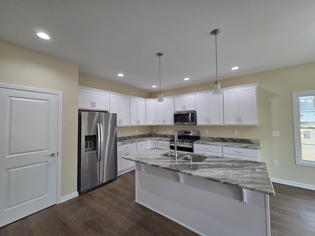 kitchen with white cabinetry, stainless steel appliances, dark wood-style floors, and baseboards