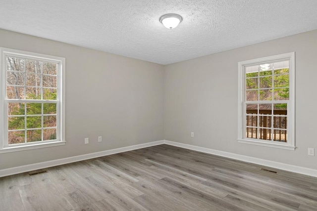 spare room featuring a textured ceiling and hardwood / wood-style flooring