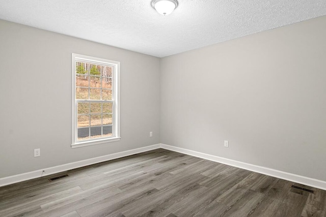 unfurnished room with hardwood / wood-style floors and a textured ceiling