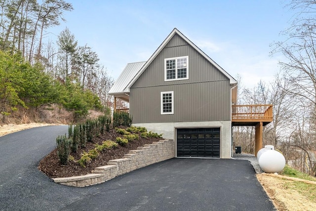 view of home's exterior with a garage and a wooden deck