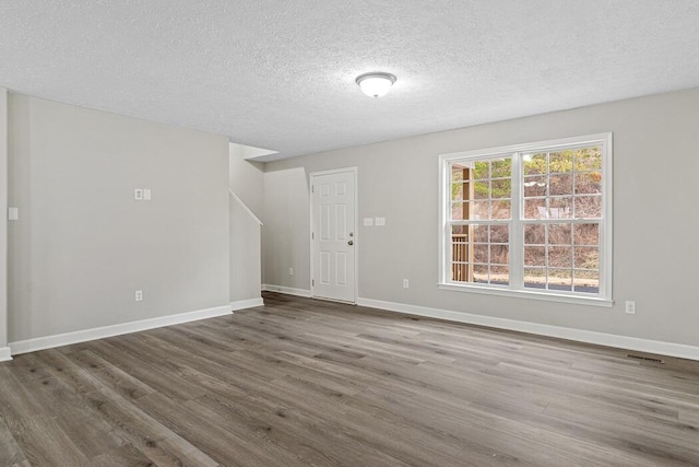 spare room with dark hardwood / wood-style flooring and a textured ceiling