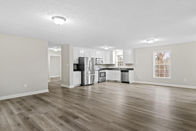 unfurnished living room featuring dark hardwood / wood-style flooring and a textured ceiling