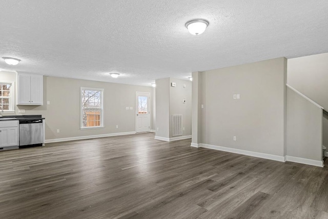 unfurnished living room with dark hardwood / wood-style floors and a textured ceiling