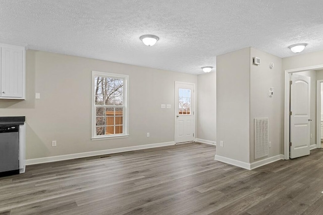 unfurnished dining area with dark hardwood / wood-style floors and a textured ceiling