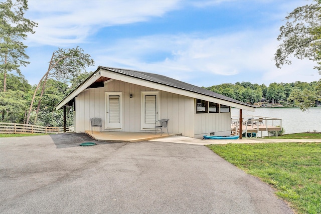 view of outbuilding with a yard and a water view