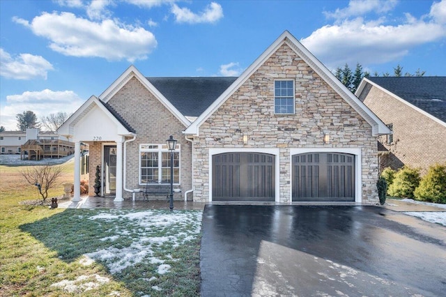 view of front of house featuring a garage, aphalt driveway, and brick siding