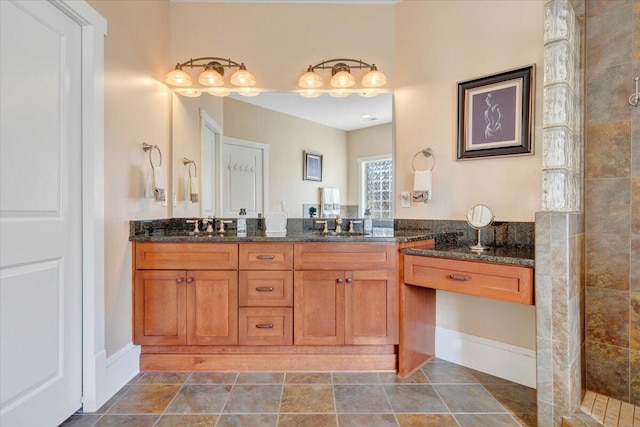 bathroom featuring tiled shower, a sink, and double vanity