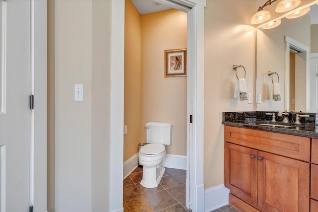 bathroom featuring tile patterned flooring, vanity, toilet, and baseboards