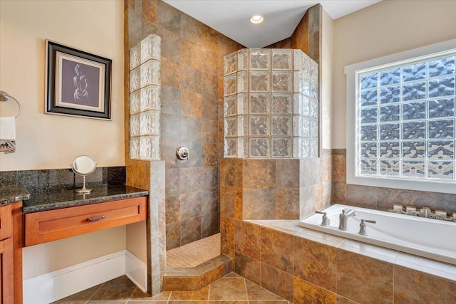 full bath with tile patterned flooring, walk in shower, a bath, and vanity