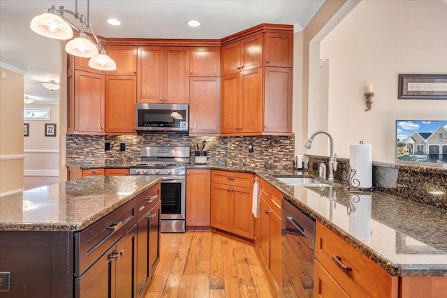 kitchen with light wood-style flooring, stainless steel appliances, a peninsula, a sink, and tasteful backsplash