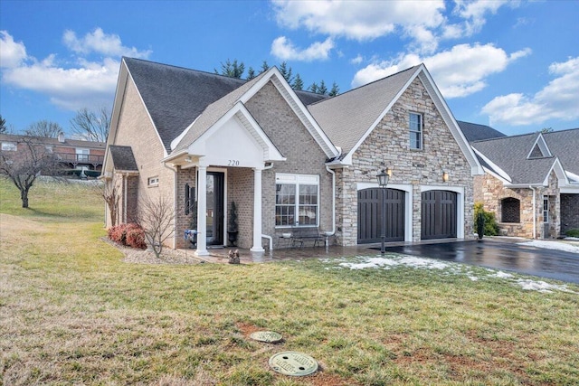 view of front facade featuring a garage, stone siding, aphalt driveway, a front lawn, and brick siding