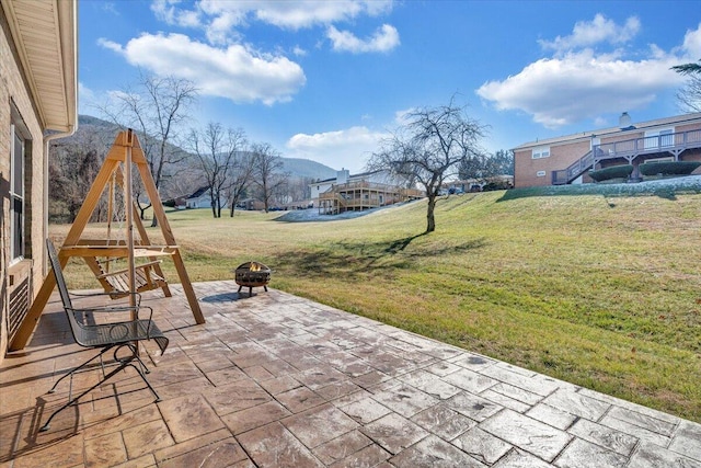 view of patio with an outdoor fire pit and a mountain view