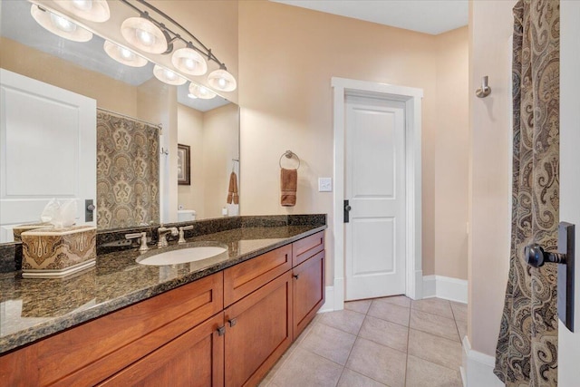 full bath featuring toilet, tile patterned flooring, vanity, and baseboards