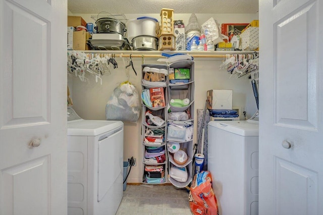 laundry room featuring a textured ceiling and washing machine and clothes dryer