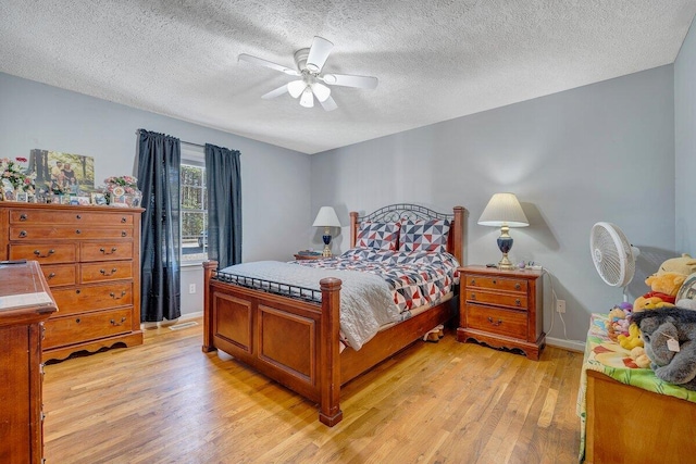 bedroom with a textured ceiling, ceiling fan, and light hardwood / wood-style flooring