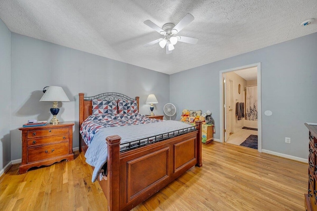 bedroom with a textured ceiling, ceiling fan, ensuite bathroom, and light hardwood / wood-style flooring