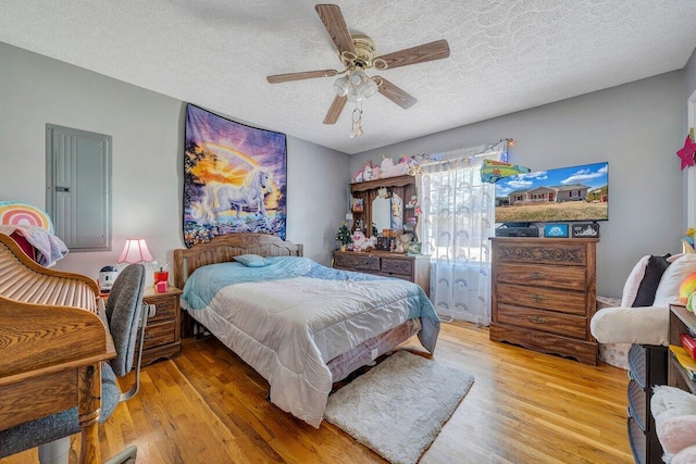 bedroom with ceiling fan, a textured ceiling, and wood-type flooring