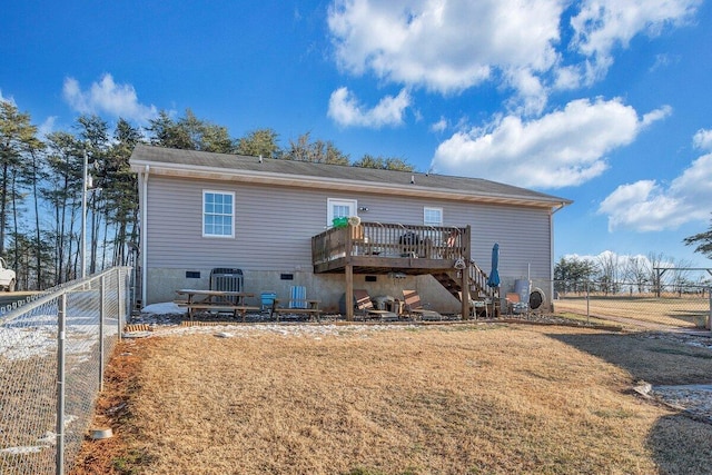 rear view of house featuring central AC unit, a wooden deck, and a yard