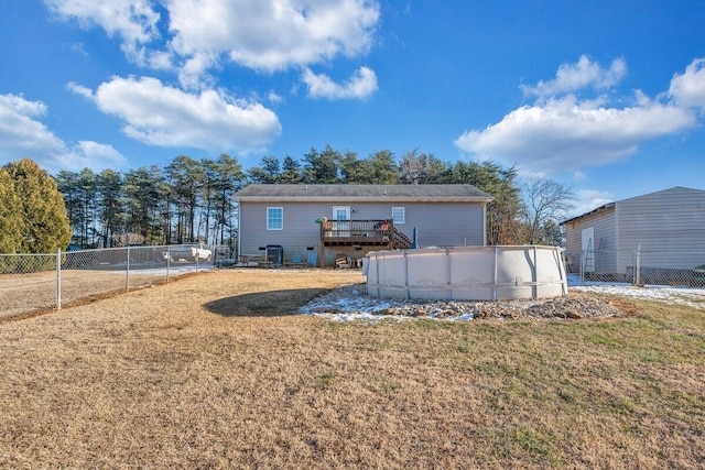 back of house featuring central AC unit, a swimming pool side deck, and a lawn