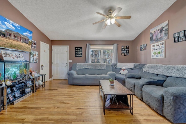 living room featuring a textured ceiling, ceiling fan, lofted ceiling, and light hardwood / wood-style floors