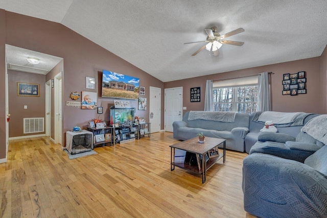 living room featuring a textured ceiling, ceiling fan, lofted ceiling, and light hardwood / wood-style floors