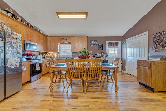 dining area featuring plenty of natural light, sink, and light wood-type flooring