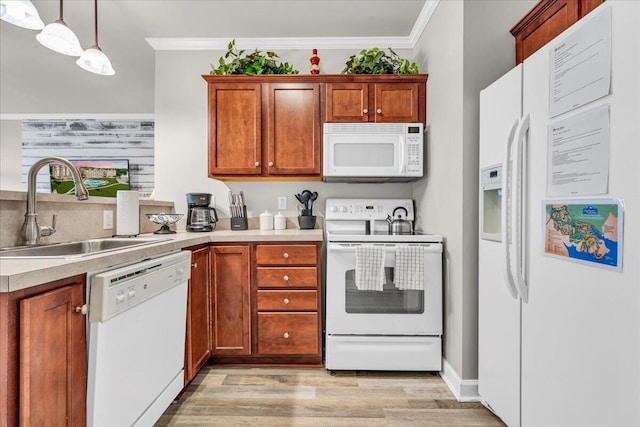 kitchen featuring white appliances, hanging light fixtures, crown molding, light hardwood / wood-style flooring, and sink