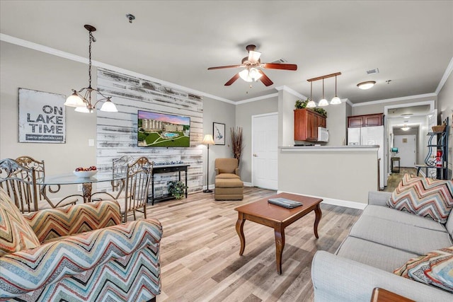 living room with light hardwood / wood-style floors, wooden walls, crown molding, and ceiling fan with notable chandelier