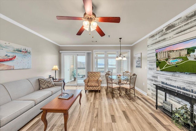 living room featuring ornamental molding, ceiling fan with notable chandelier, and light hardwood / wood-style flooring