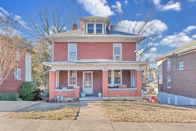 view of front of home featuring covered porch and a front lawn