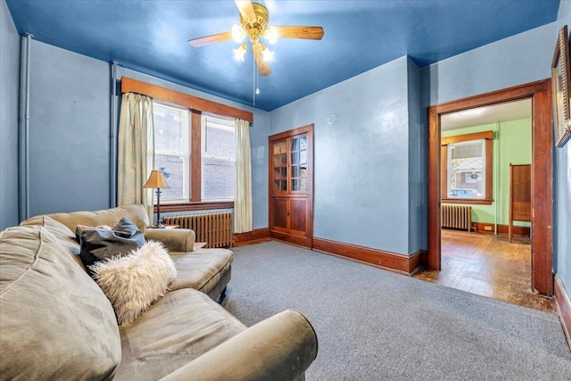 living room featuring ceiling fan, carpet, and radiator