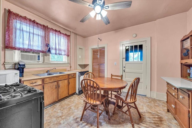 dining space featuring ceiling fan and sink