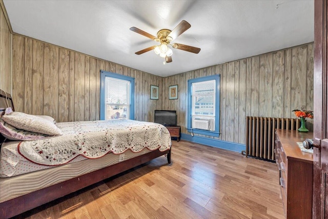 bedroom featuring ceiling fan, radiator heating unit, and light hardwood / wood-style flooring