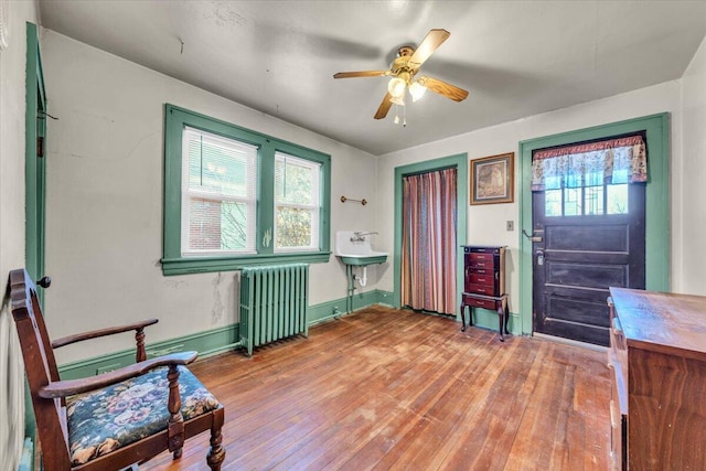 foyer entrance featuring ceiling fan, radiator heating unit, plenty of natural light, and wood-type flooring